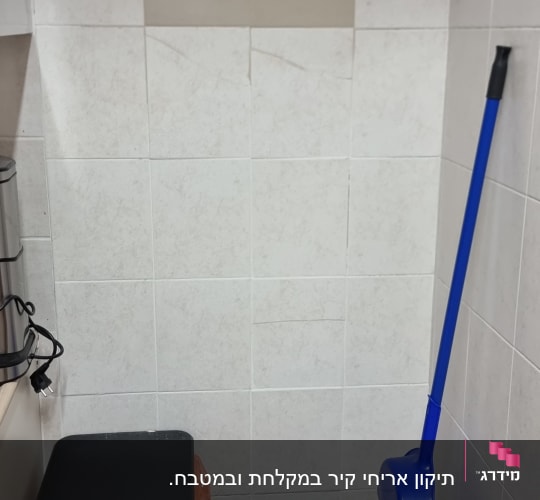 מטאטא ומגב כחול ליד פח אשפה